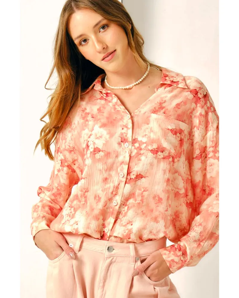 Lisa in a coral floral print shirt and pearl necklace